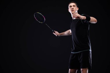 Badminton oyuncusu spor giyim sektöründe raket ve siki siyah arka planda. Bireysel sporlar. Spor eğlencesi..