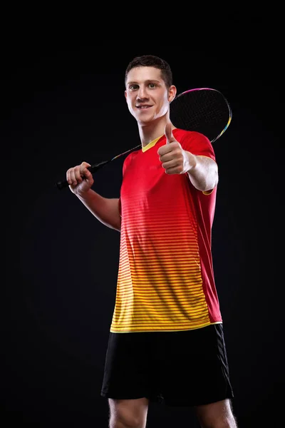 Badmintonspieler in Sportbekleidung mit Schläger und Federball auf schwarzem Hintergrund. Individuelle Sportarten. Sportliche Erholung. — Stockfoto