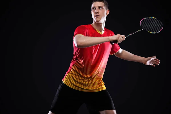 Badmintonspieler in Sportbekleidung mit Schläger und Federball auf schwarzem Hintergrund. Individuelle Sportarten. Sportliche Erholung. — Stockfoto