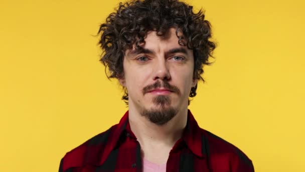 Close-up retrato de feliz sorrindo cara com cabelos cacheados olhando para câmera isolada no fundo amarelo — Vídeo de Stock