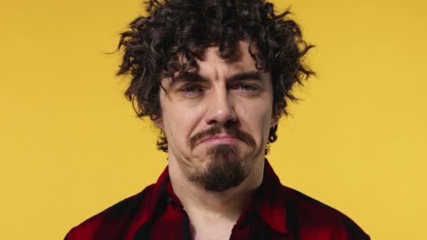 Closeup portrait of sad crying guy with curly hair isolated on yellow background — 图库视频影像