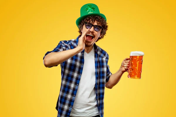 День Святого Патрика. Молодой человек Октоберфест подает большую кружку пива с напитком изолированы на желтом фоне. Парень показывает знак ОК с пальцами . — стоковое фото