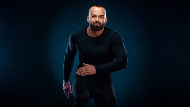 Sıkıştırma giysili genç kaslı sporcu. Spor salonunda egzersiz.