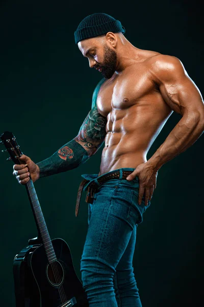 Bodybuilder uomo forte e in forma con guitrar mostra muscoli addominali. Atleta muscoloso sportivo. Sport e fitness concept. Moda uomo . — Foto Stock