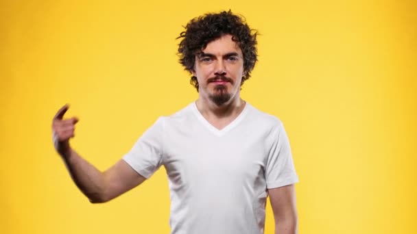 Camiseta blanca sobre una plantilla de hombre joven aislada sobre fondo amarillo — Vídeo de stock