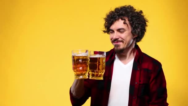 Saint Patrick. Jeune homme Oktoberfest servant une grande tasse de bière avec boisson isolée sur fond jaune . — Video