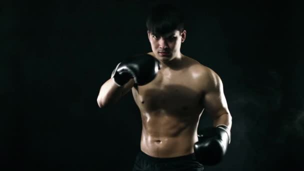 Shadow-boxing concept. Boxer man in gloves fighting with shadow on black background. Individual sports recreation. Slow Motion. — Stock Video