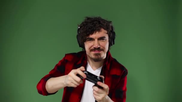 Nerdy gamer with controller on yellow background. Man with curly hair. Chroma key. Slow motion. — Stock Video