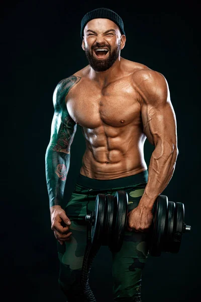 Man athlete bodybuilder. Muscular young fitness sports guy doing workout with dumbbell in fitness gym — Stock Photo, Image