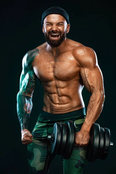 Homem atleta fisiculturista. Muscular jovem fitness esportes cara fazendo treino com haltere no ginásio de fitness — Fotografia de Stock