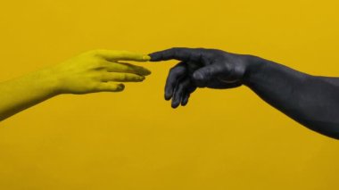 Erkek ve kadının birbirine yakın elleri. Siyah vücut boyalı vücut geliştirme sporcusu. Bodyart 'lı kız ve erkeğin renkli portresi.