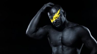 Adamın iyi bir fikri var. Sarı yüzlü ve siyah vücut boyalı vücut geliştirme sporcusu. Bodyart 'lı adamın renkli portresi.