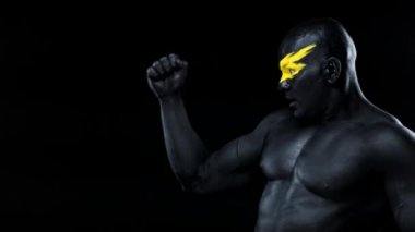 Adam kopyalama alanını seçiyor. Sarı yüzlü ve siyah vücut boyalı vücut geliştirme sporcusu. Bodyart 'lı adamın renkli portresi.