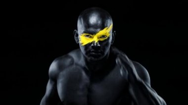 Vücudunda kadın eli olan bir adam. Sarı yüzlü ve siyah vücut boyalı vücut geliştirme sporcusu. Bodyart 'lı adamın renkli portresi.