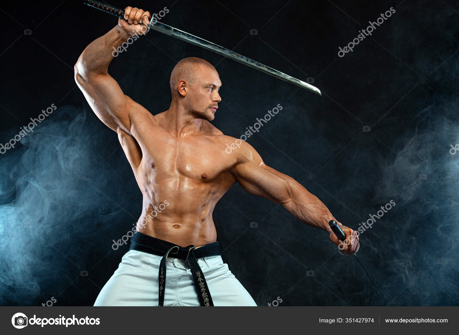 Karate fighter on black background with smoke. Shirtless man samurai