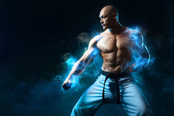 Karate or taekwondo fighter on black background with smoke. Fit man sportsmen bodybuilder physique and athlete. Mens sport motivation. — Stock Photo, Image