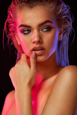 Young blonde woman posing on light background