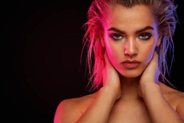Young blonde woman posing on light background