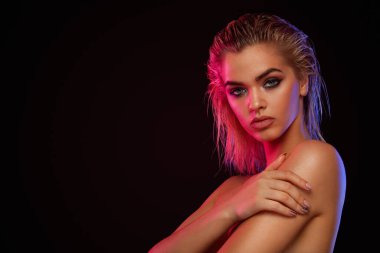 Young blonde woman posing on light background