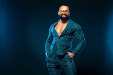 Zarif takım elbiseli çıplak vücutlu yakışıklı bir vücut geliştiricinin portresi.