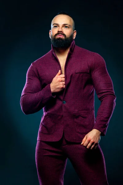 Porträt eines gut aussehenden bärtigen Mannes Bodybuilder im roten Anzug — Stockfoto