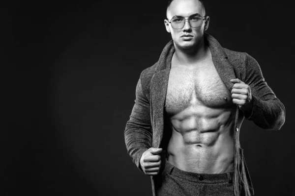 Portrait of handsome stylish man bodybuilder with naked torso in elegant suit. Guy in glasses. Black and white photo — Stock Photo, Image