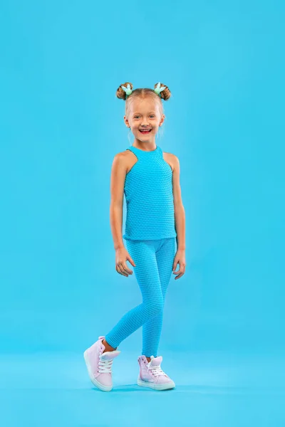 小女孩穿着运动服,穿着粉色和粉色背景的运动服进行健身锻炼.体育概念. — 图库照片