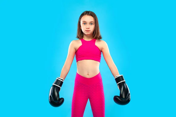 Concepto de boxeo y fitness. Deportista, niña boxeadora peleando con guantes sobre fondo azul . — Foto de Stock