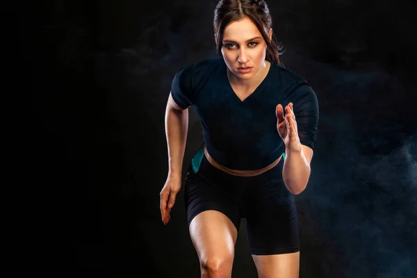 Sprinter e Runner Girl. Concetto in esecuzione. Donna che corre sullo sfondo nero. Il concetto di uno stile di vita sano e sport. Donna in abbigliamento sportivo . — Foto Stock