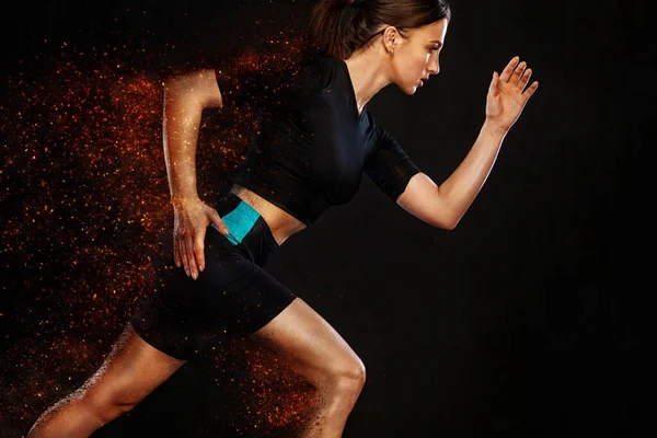 Sprinter a běžkyně. Běžící koncept. Fitness a sportovní motivace. Silný a fit atlet, žena sprinter nebo běžec, běh na černém pozadí v ohni na sobě sportovní oblečení. — Stock fotografie