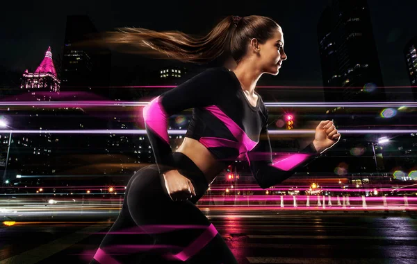 Fitness and sport motivation. Strong athletic woman sprinter, running in the night city. Girl model wearing sportswear outfit. Runner concept.