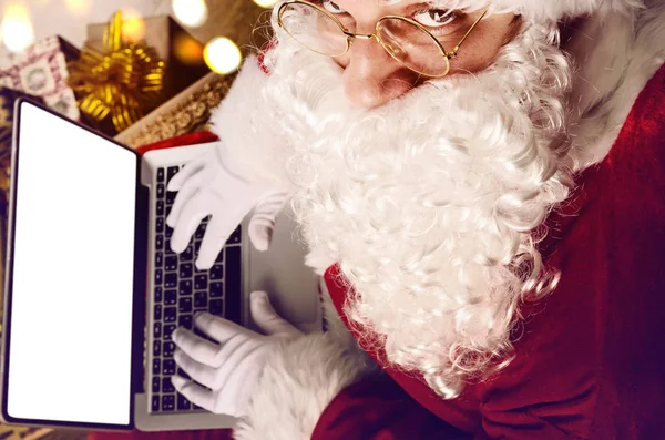 Weihnachtsmann arbeitet an modernem Laptop — Stockfoto