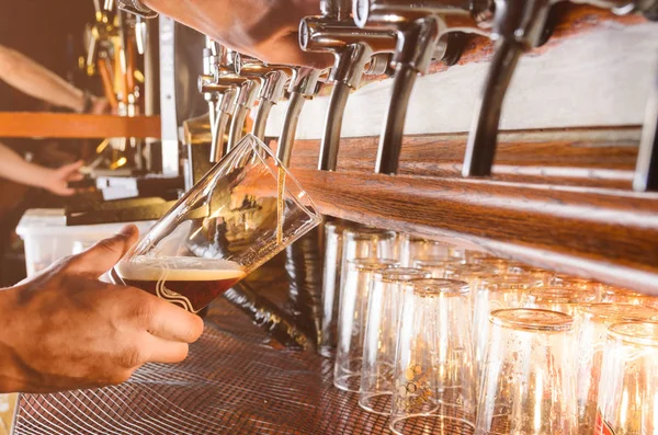 Barman ten dienste staat van bier uit de kraan — Stockfoto