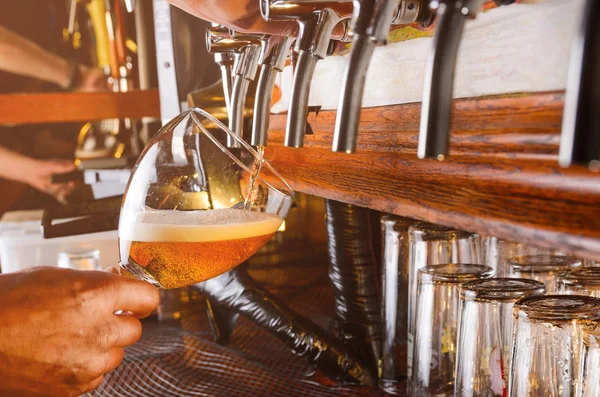 Barman is serving beer from faucet — Stock Photo, Image