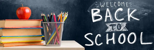 School accessories against blackboard — Stock Photo, Image