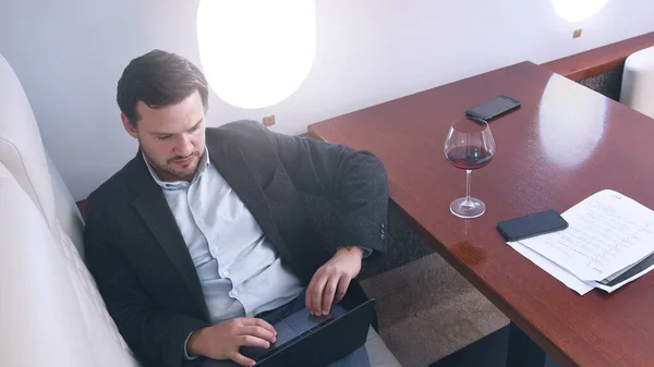 Businessman works on private plane — Stock Photo, Image