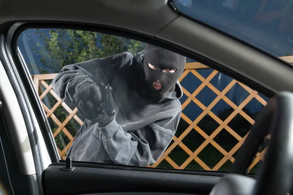 Vilain avec une arme menaçant le conducteur — Photo