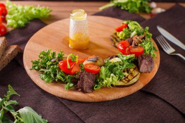 Salata yaprakları dilimlenmiş biftek ve kurutulmuş domates ile