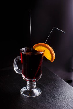 Şeffaf cam siyah arka plan üzerine tarçın ile mulled şarap