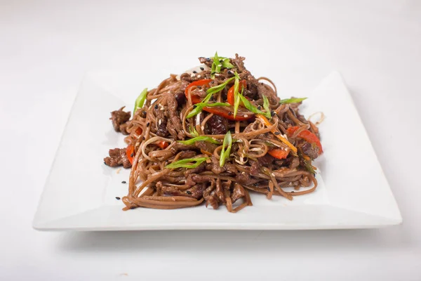 Buğday noodle ile tavuk teriyaki beyaz bir arka plan üzerinde