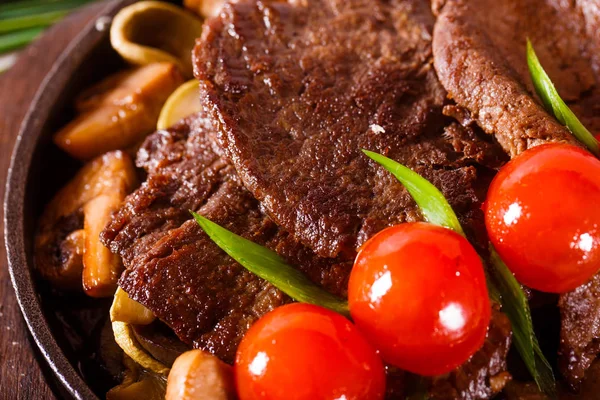 Carne frita em uma panela com tomates cereja — Fotografia de Stock