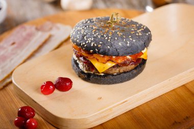 Pastırma ve sosu bir ahşap stand ile siyah hamburger