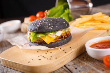 Pastırma ve sosu bir ahşap stand ile siyah hamburger