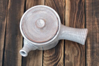 Ahşap zemin üzerinde beyaz çaydanlık