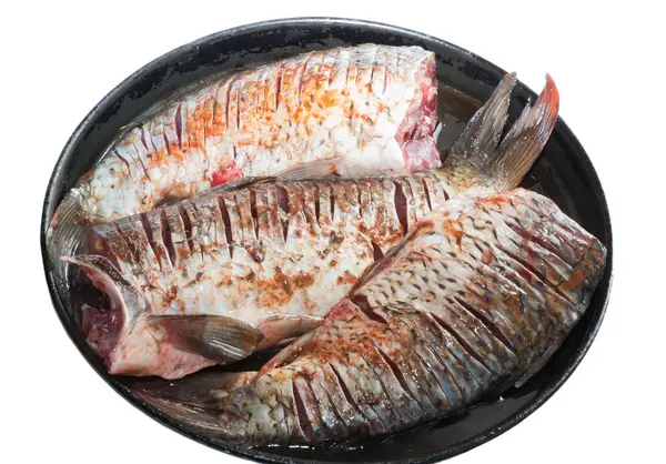 Carpa de pescado crudo en una bandeja de metal. Pescado espolvoreado con especias — Foto de Stock