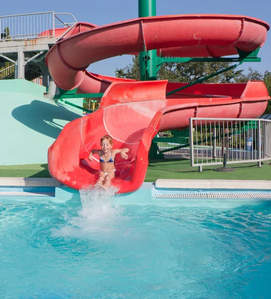 Belle enfant rousse sur un toboggan dans le parc aquatique . — Photo