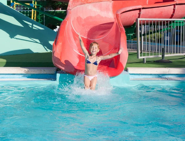 Bela criança ruiva em um slide no parque aquático . — Fotografia de Stock