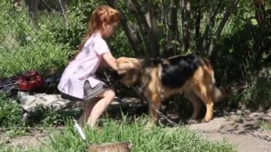 Güzel kızıl saçlı, tüylü köpekli bir kız. Köpeğin cinsi bir Alman çoban köpeği.