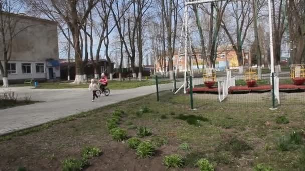 Παιδιά Τρέχουν Και Οδηγούν Ένα Σκούτερ Στο Πάρκο — Αρχείο Βίντεο
