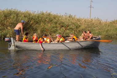 Primorsko-Akhtarsk, Rusya - 15 Eylül 2017: Okul çocuğu yazın nehirde tahta bir teknede kürek çekiyor